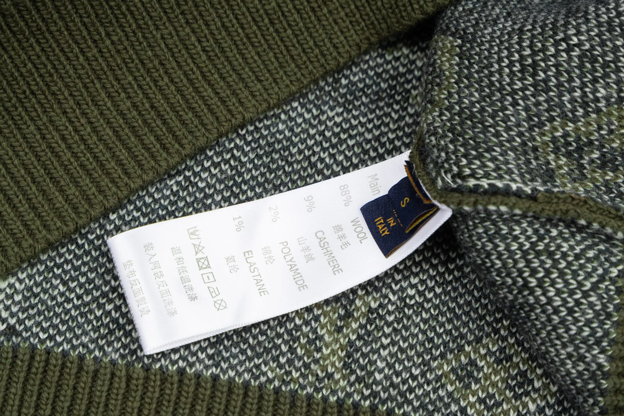 🅿️560 1v 26SS all-over green camouflage jacquard crew neck sweater. The original version was purchased and developed for 16,360 yuan. The fabric is made of high-quality wool blended fabric, which is soft to the touch and has excellent warmth retention. The overall design adopts a round neck, and the collar, cuffs and hem are all ribbed, with moderate elasticity, comfortable to wear and not easy to deform. The main part uses jacquard technology, and the pattern is composed of the brand's iconic letters and geometric figures. The colors are distinct and the three-dimensional effect is strong. Multi-colored yarns are interwoven during the jacquard process to ensure clear patterns and long-lasting washability. The knitting density is uniform and the number of stitches per inch is precisely controlled to ensure the stiffness and breathability of the clothing. The splicing of the shoulders and sleeves adopts seamless technology, with smooth and natural lines without excess threads. The overall workmanship is fine, and every stitch is even and neat, reflecting the high-quality production process. The overall wiring is straight and delicate, the fabric is comfortable and soft, and the color is consistent without color difference. It can be matched with the same style to create a fashionable look and control various occasions. Customized accessories, complete with three standards, the same style for men and women. Size:S-M-L-XL